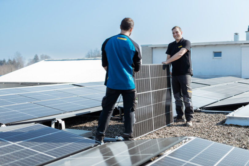 Zwei Mitarbeiter bei der Installation eines Photovoltaikmoduls
